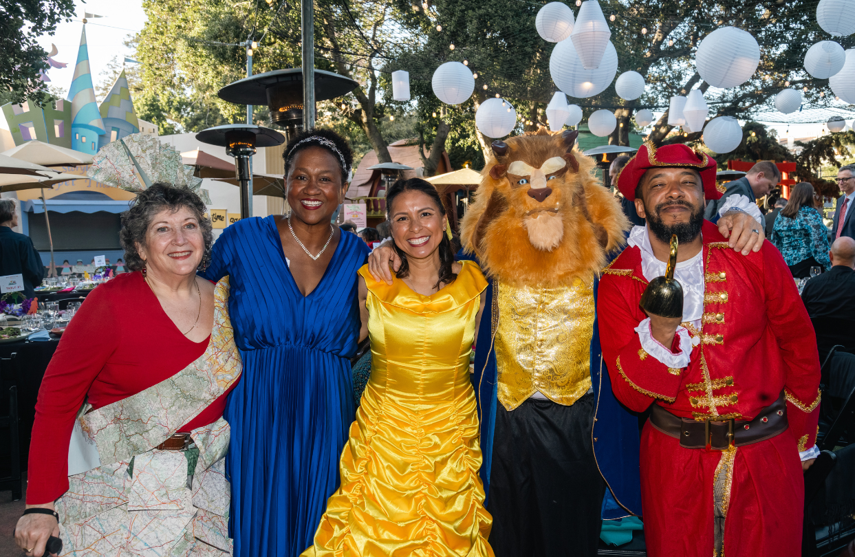 Five happy guests in thematic costumes