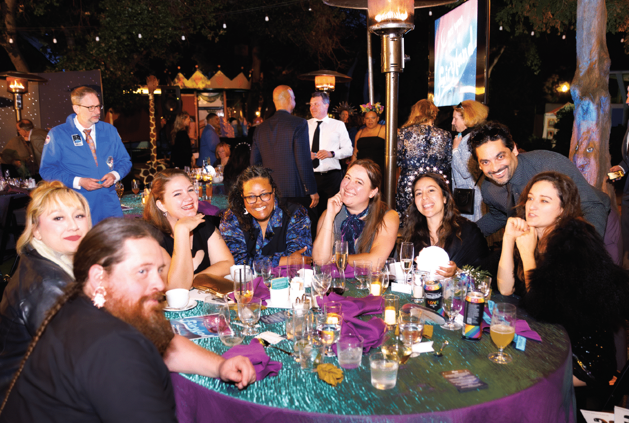Eight happy guests seated for dinner