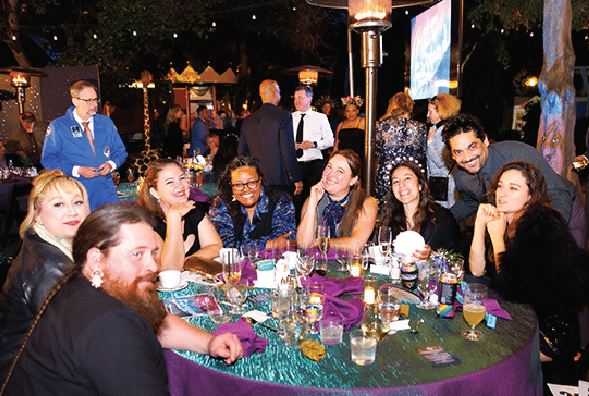 Eight happy guests seated for dinner