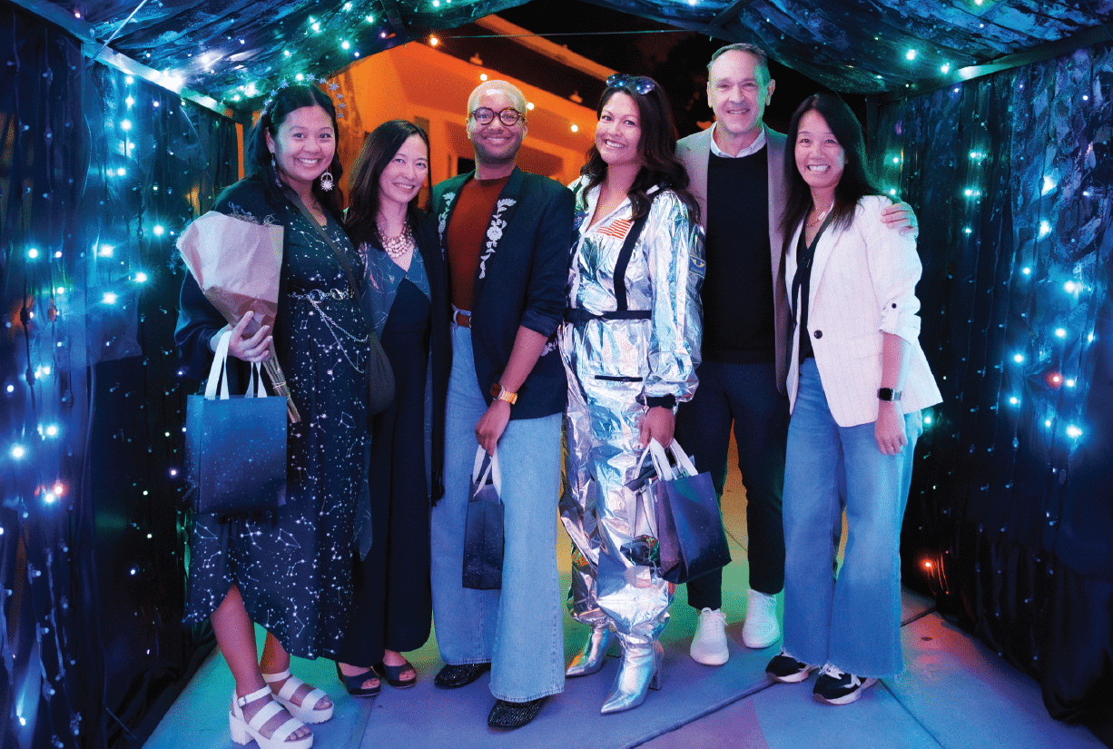 Six happy guests at night in a glowing light tunnel