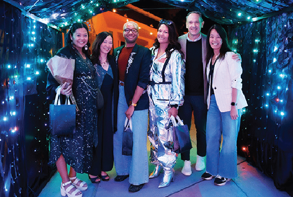 Six happy guests at night in a glowing light tunnel